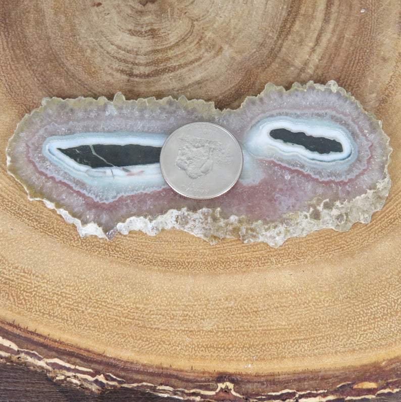 Light Amethyst Stalactite with a quarter on top of it for size reference
