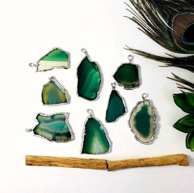 multiple green agate pendants displayed t o show various colors shapes sizes