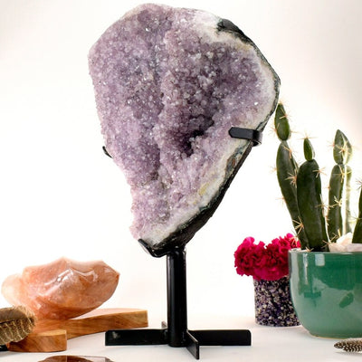 Large amethyst cluster on a black metal stand.