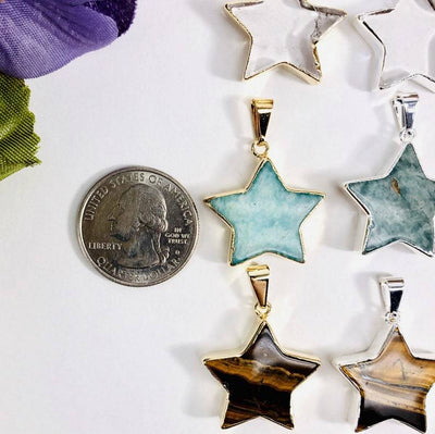 star pendants displayed by quarter for size reference