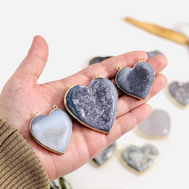Three Agate Druzy Hearts with connectors in a hand.