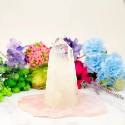 Crystal Quartz Polished Tower  on  display with flowers