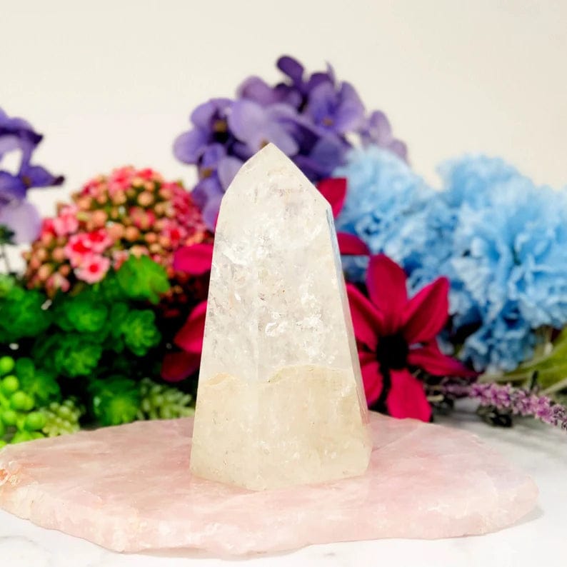 Crystal Quartz Polished Tower front view on a flowery background (flowers not included)