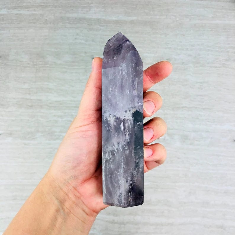 Amethyst Polished Tower Point side view in a hand for size