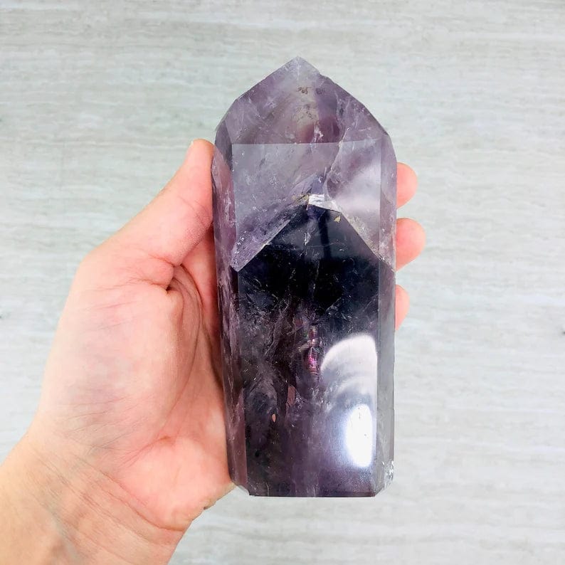 Amethyst Polished Tower Point, showing the best angle to see the second point growing inside, in a hand for size reference
