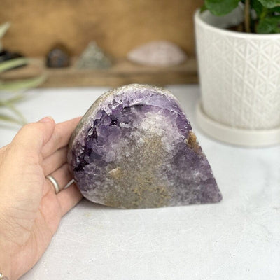 Amethyst Freeform Cut Base with a hand for size reference