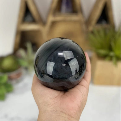Black Obsidian Sphere in a hand for size