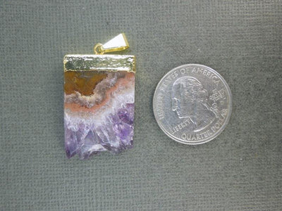 amethyst slice pendant next to a quarter