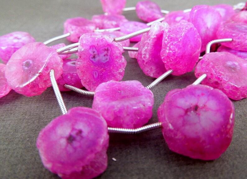 Pink Solar Quartz Beads on thread laid on top of table to show color/size difference