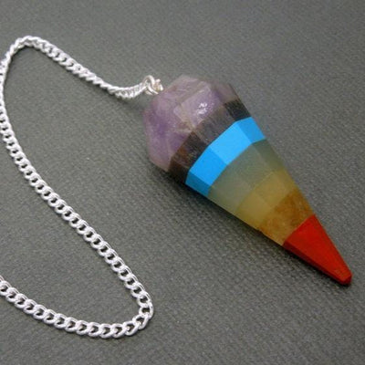 close up of one seven chakra point pendulum with silver plated chain on display for details