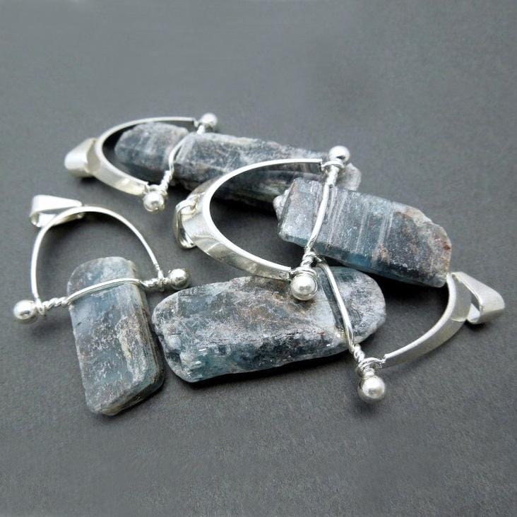4 blue kyanite pendants in a pile
