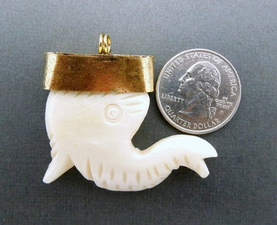 one carved elephant bone pendant on a gray backgound compared with a quarter.  It is larger than the quarter.