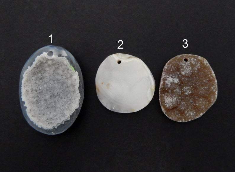 3 Different Druzy Agate in Top Center Drilled on Black Background.