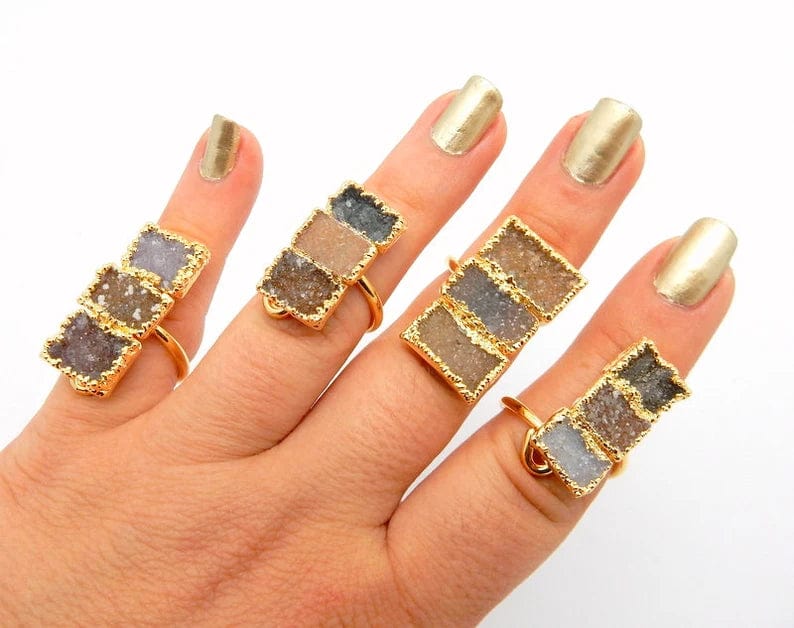 4 Triple Rectangle Druzy with Electroplated 24k Gold Edges on an Adjustable 24k Gold Electroplated Rings showing varying colors of white, tan brown, greys, darks, lavenders on a hand