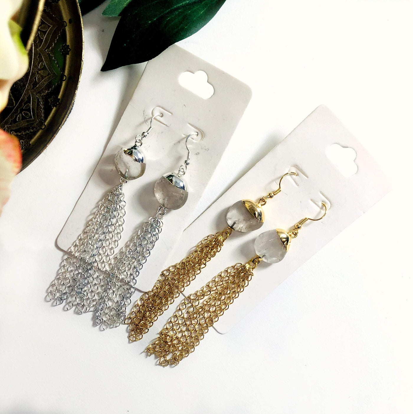 crystal quartz gold and silver earrings displayed on white background