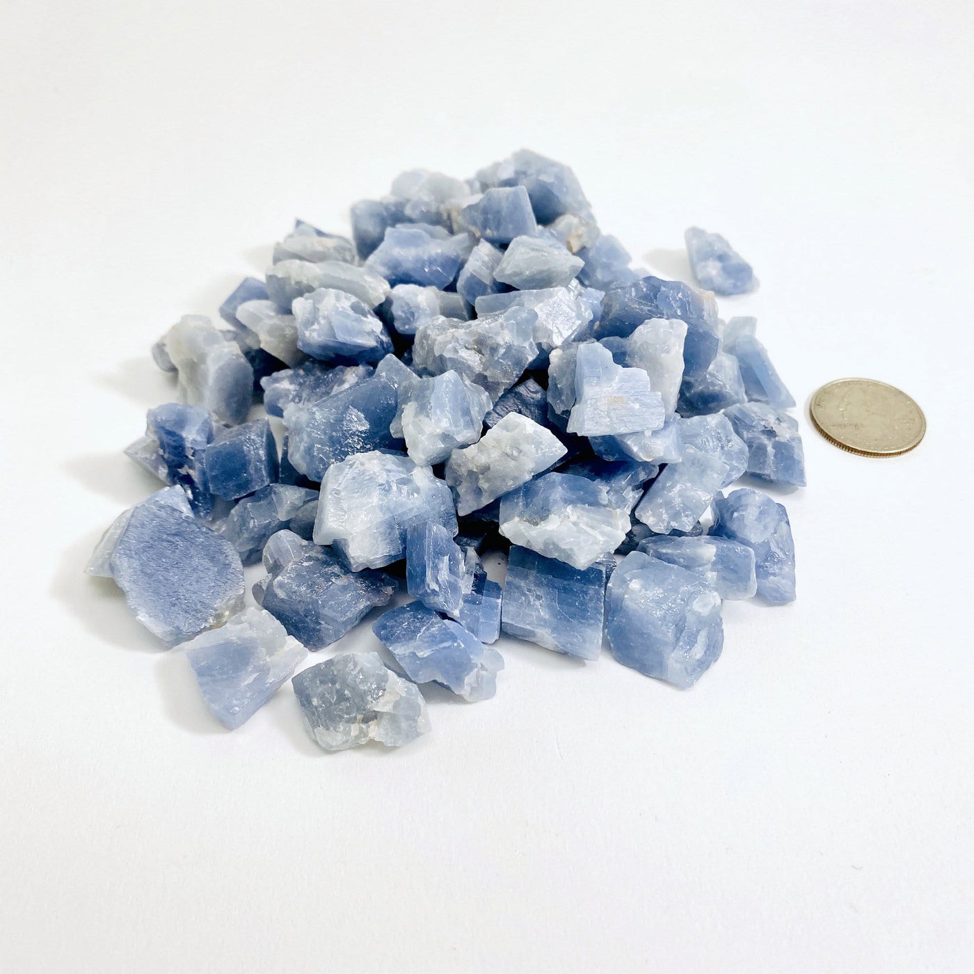 pile of blue calcite next to a quarter for size reference
