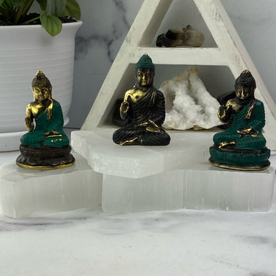 3 Buddha mini statues with decorations in the background