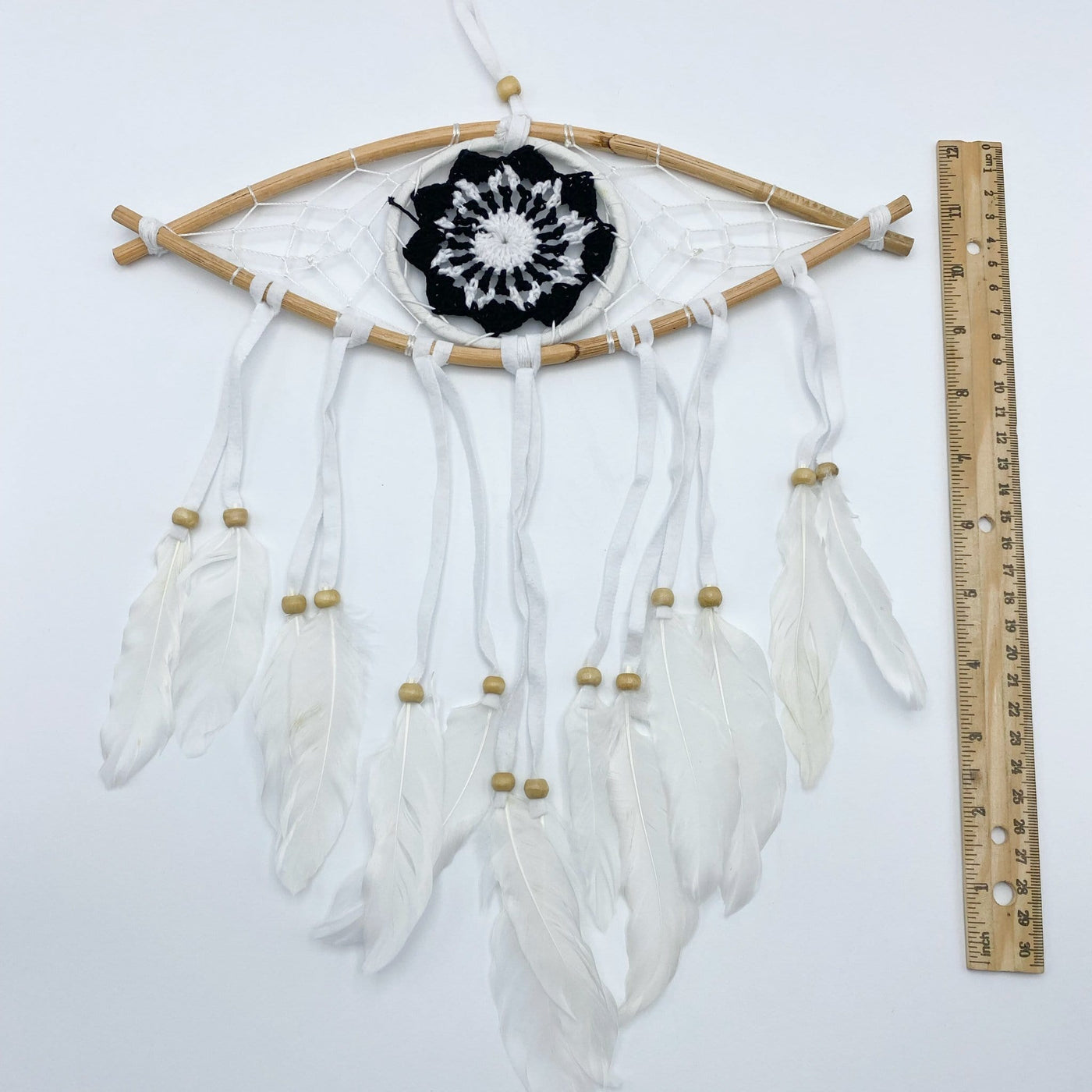 White Dream Catcher with Black All Seeing Eye Pattern next to ruler for size reference