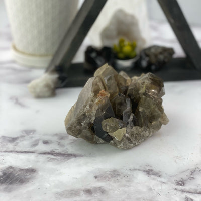 natural smokey quartz cluster in front of backdrop
