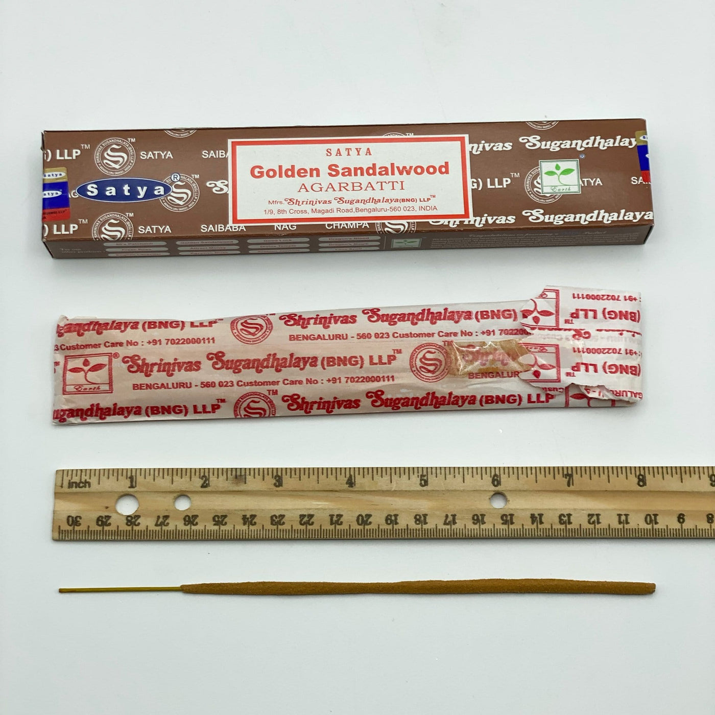 disassembled satya hand rolled golden sandalwood incense on display with ruler for size reference