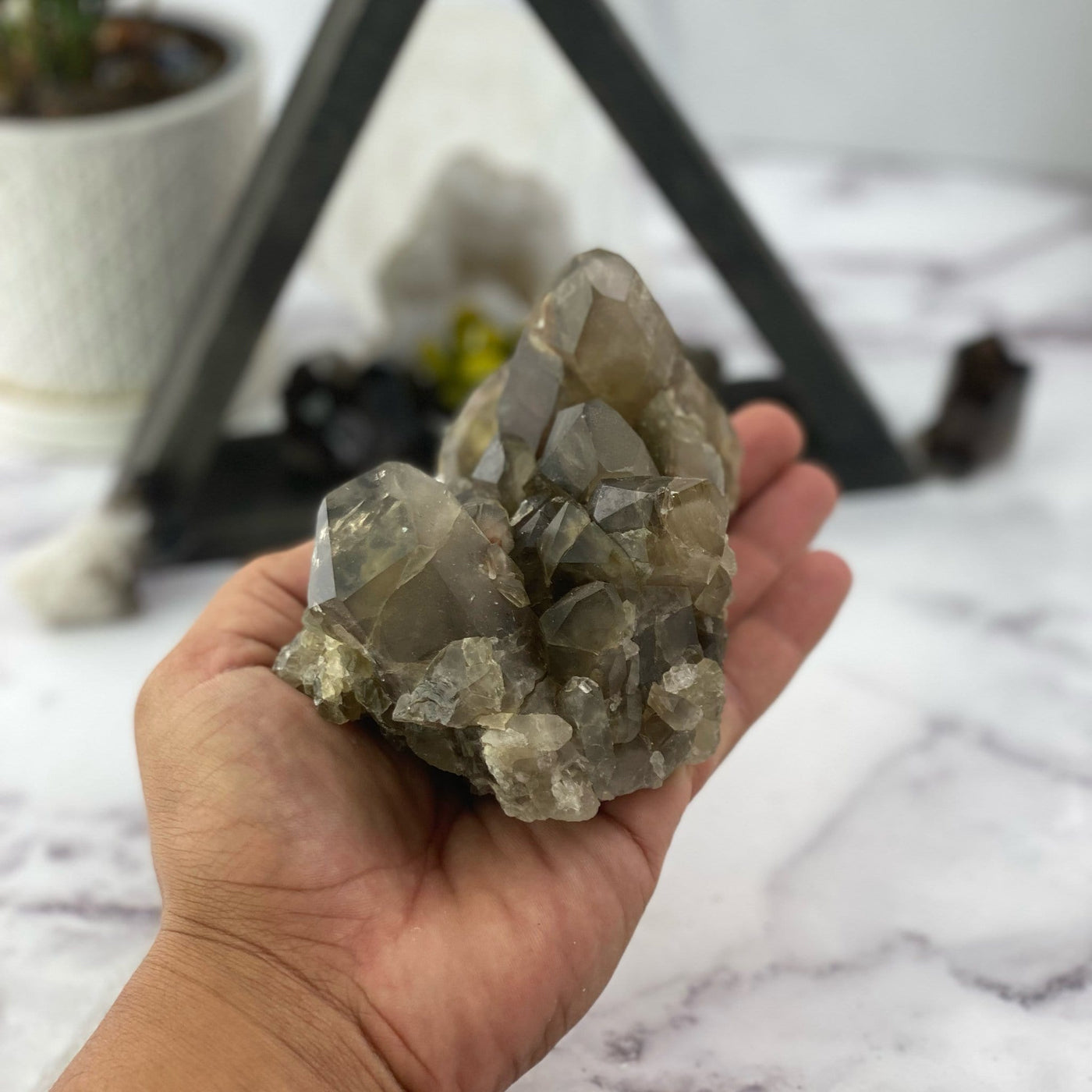 natural smokey quartz cluster in hand for size reference