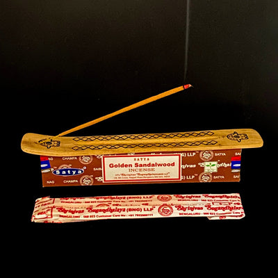 satya hand rolled golden sandalwood incense burning on display