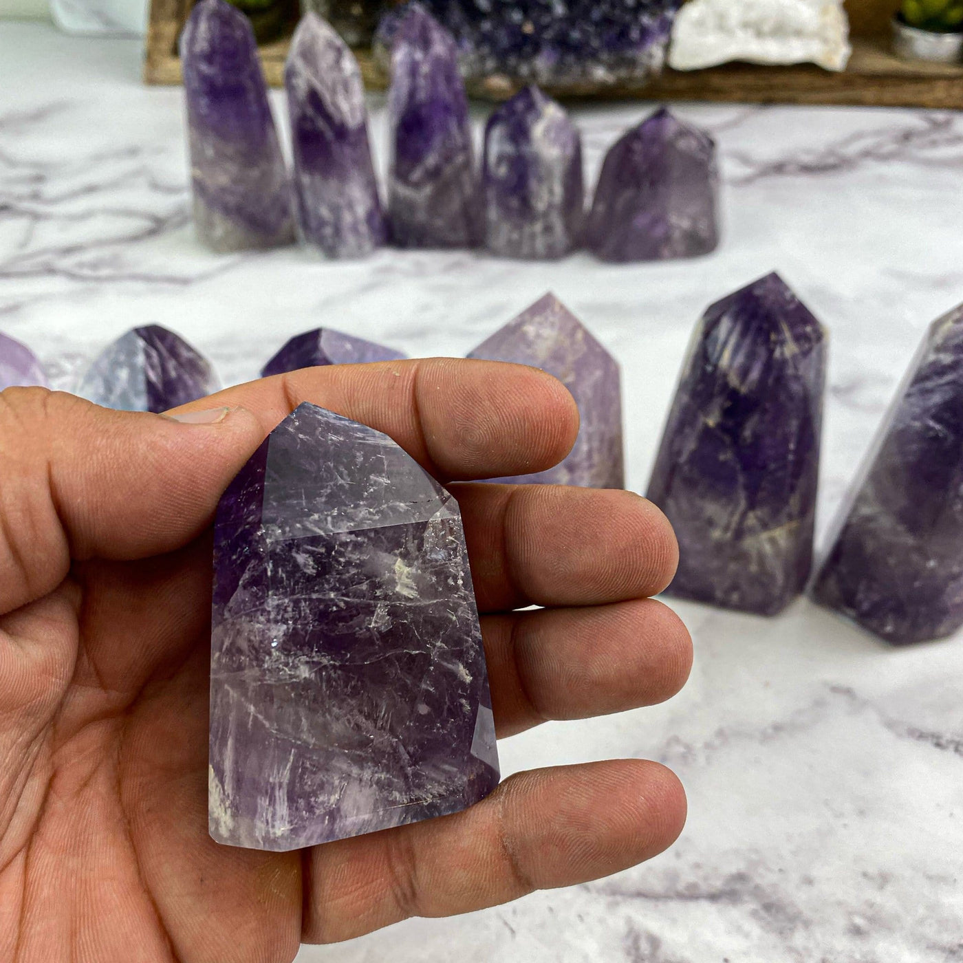 polished amethyst in hand for size reference