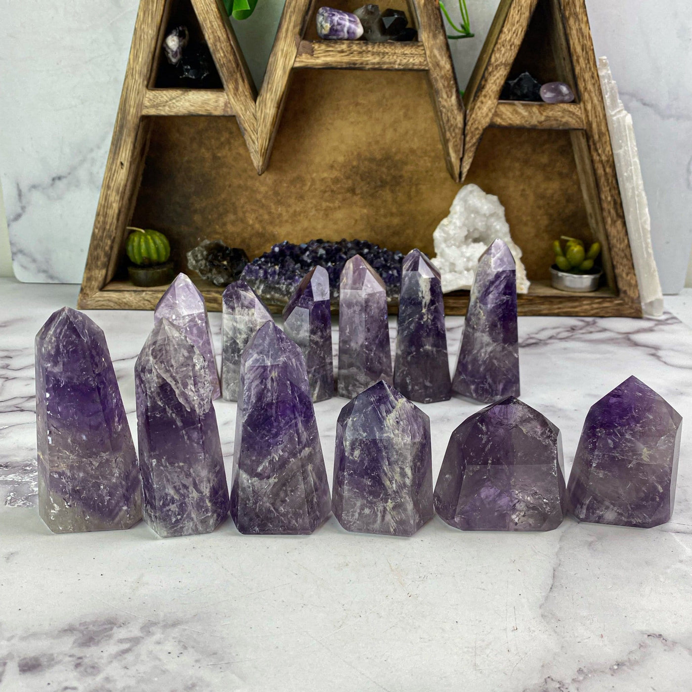 polished amethyst points lined up to show various colors and patterns