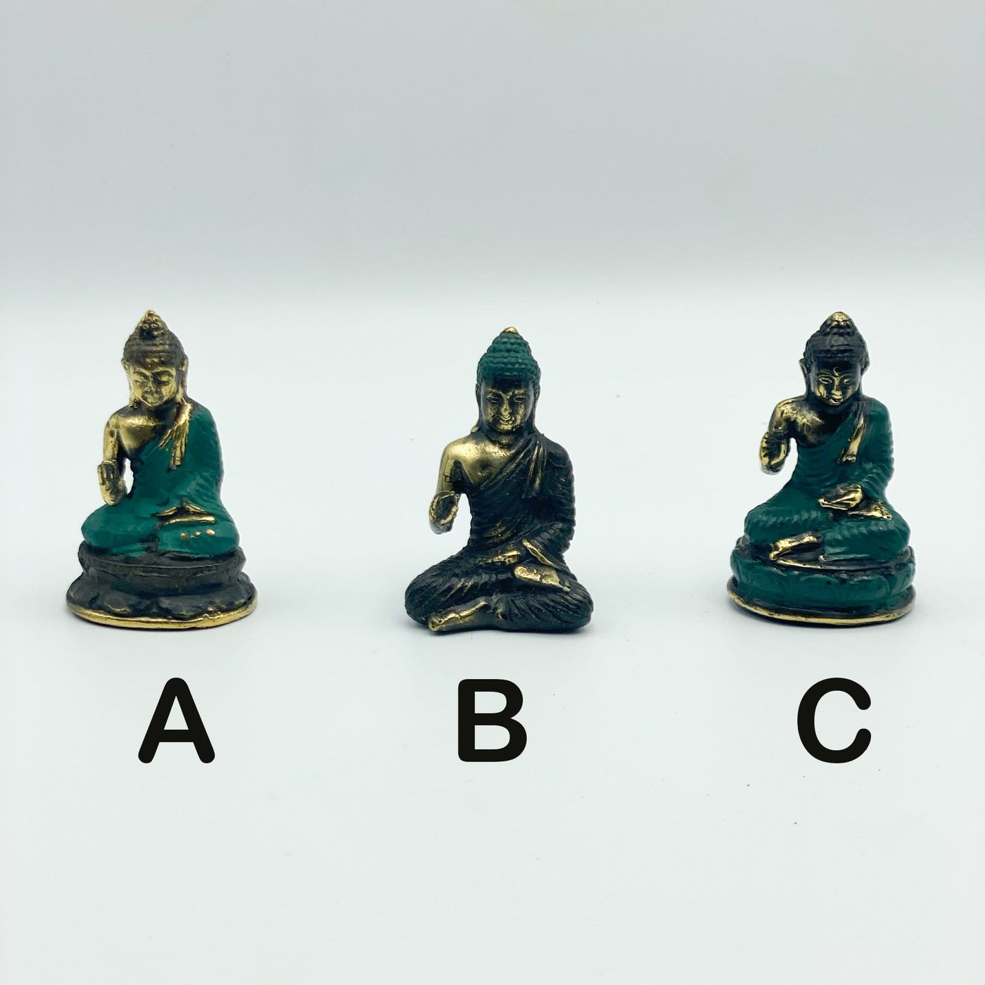 3 variations of Buddha mini statue on white background
