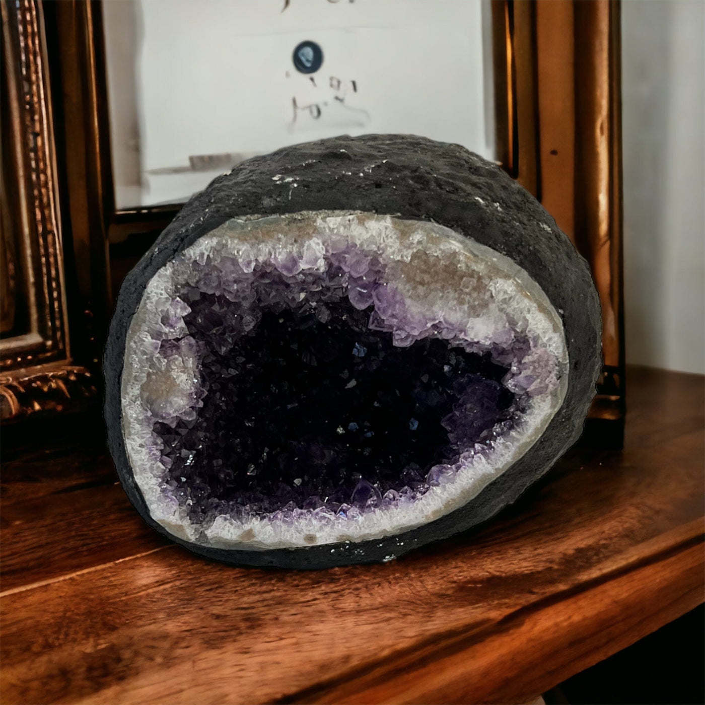 Round Amethyst Geode on a wood counter top.