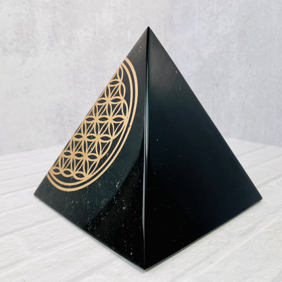 View of right side of Gold Sheen Obsidian Flower of Life Pyramid, showing off the sheen on the side.