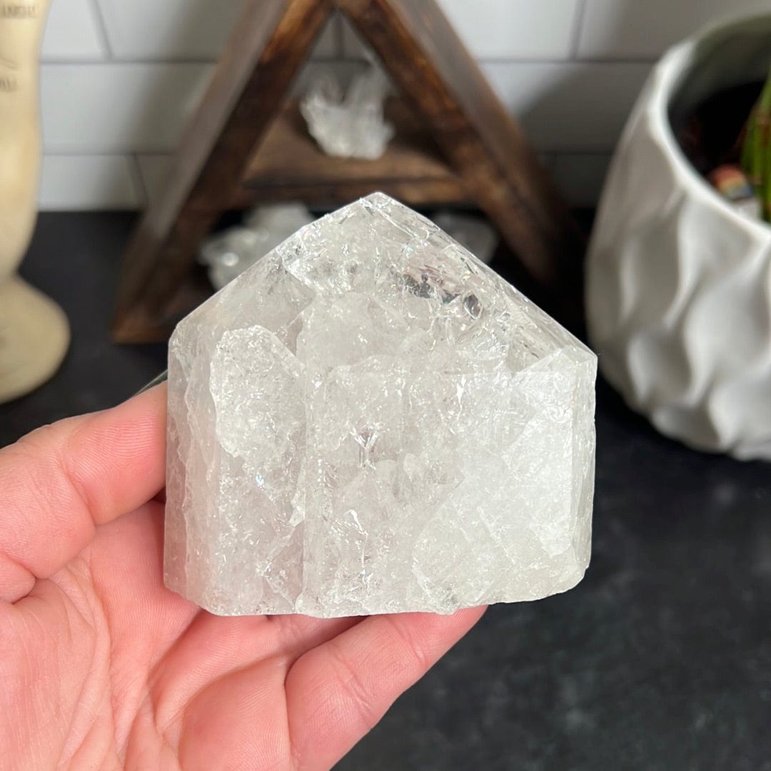 Crackle crystal quartz polished point held in a woman's hand.