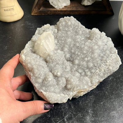 Large gray amethyst druzy cluster with one calcite formation on the top left.