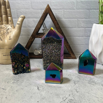 Four rainbow treated titanium amethyst towers.  They are polished on the edges with druzy centers.  The coating is mostly purple pink gold and blue.   Some teal.