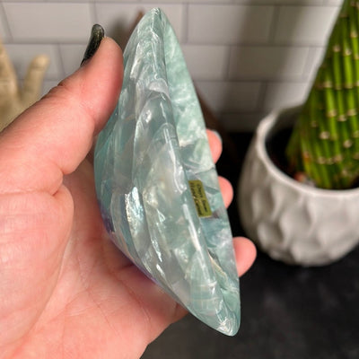 Small green fluorite bowl in a woman's hand.,