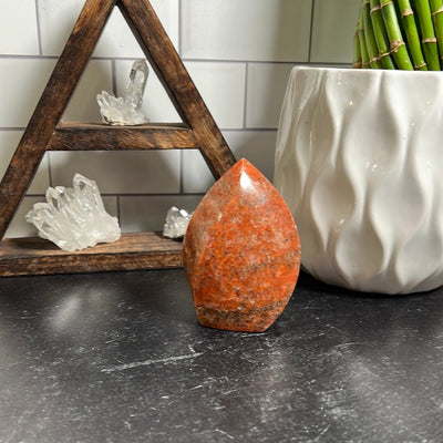 Orange calcite flame on a black background.