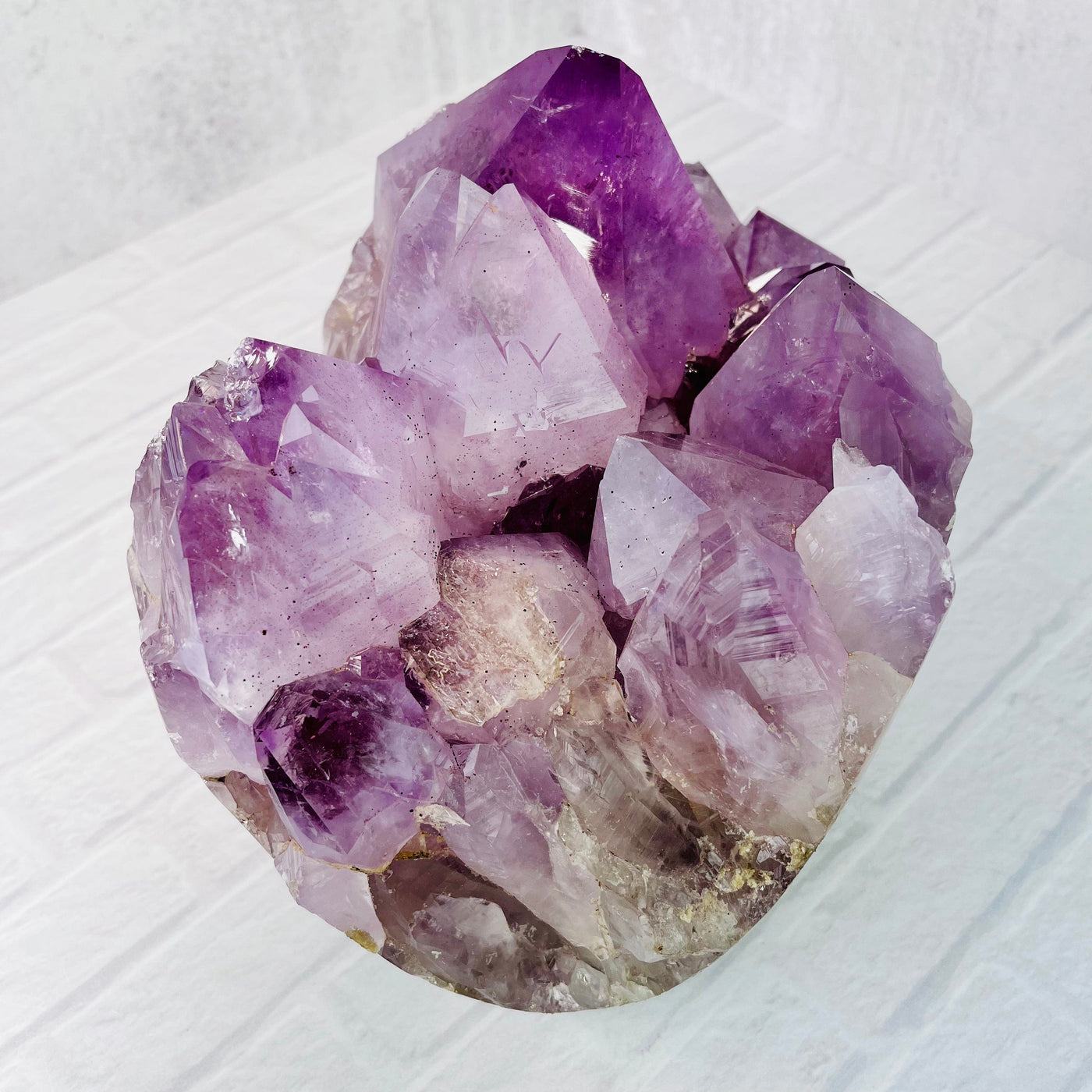 Aerial view of the Large Amethyst Point Cluster on a white surface.