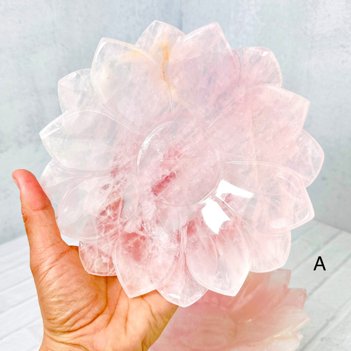 Rose Quartz Lotus Bowl A held up in woman's hand.