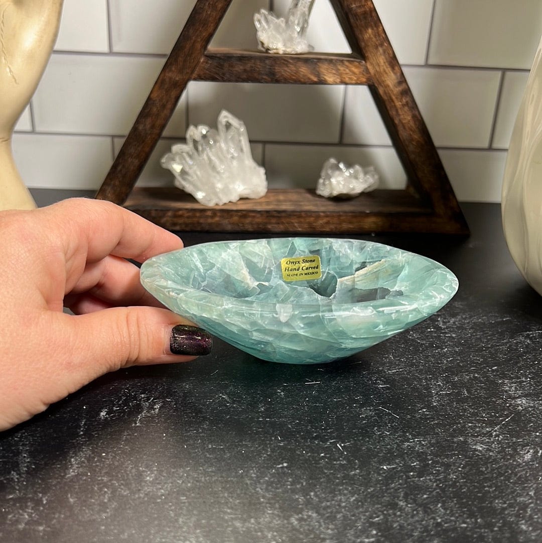 Small green fluorite bowl with a woman's hand next to it.