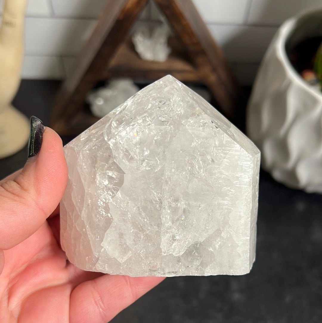 Crackle crystal quartz polished point held in a woman's hand.