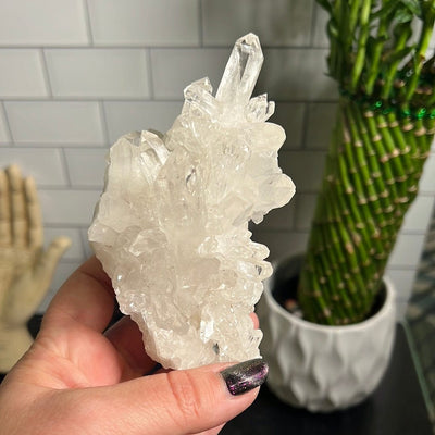 Crystal quartz cluster in a woman's hand.