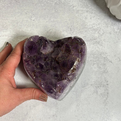 Large amethyst cluster heart purple with brownish orange spotting which is hematite or iron inclusions.