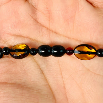 Up close view of closed bead closure on Baltic Amber Beaded Necklace, in palm of woman's hand.