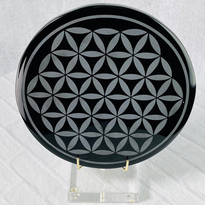 Frontal view of Black Obsidian Flower of Life Plate on a stand.