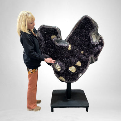 woman standing next to Amethyst Crystal Cluster Natural Shape Heart with Calcite Chunks for size reference