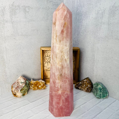 Back view of Rose Quartz Polished Tower, on a white surface.