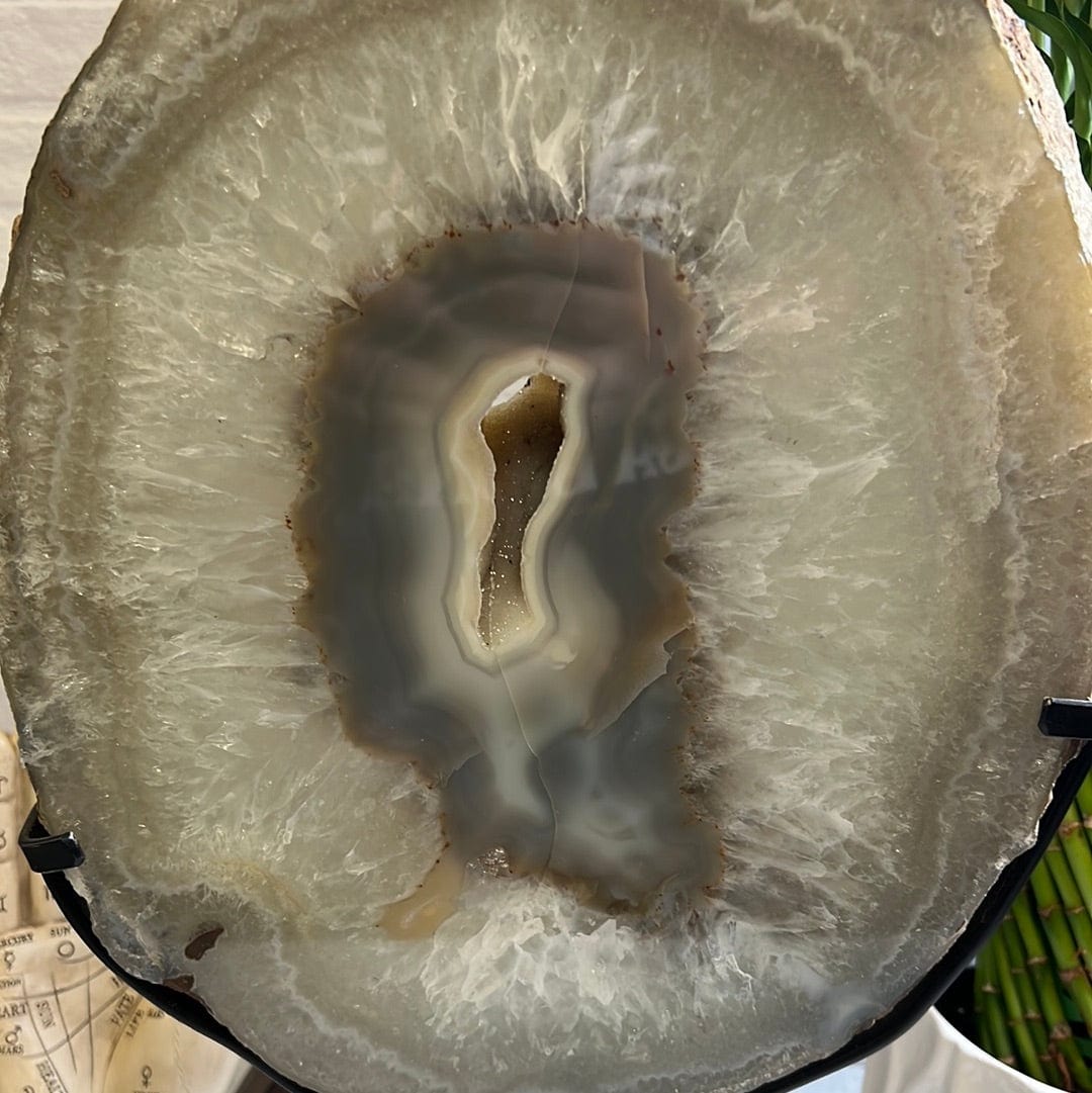close up of Agate slice on a black metal stand.
