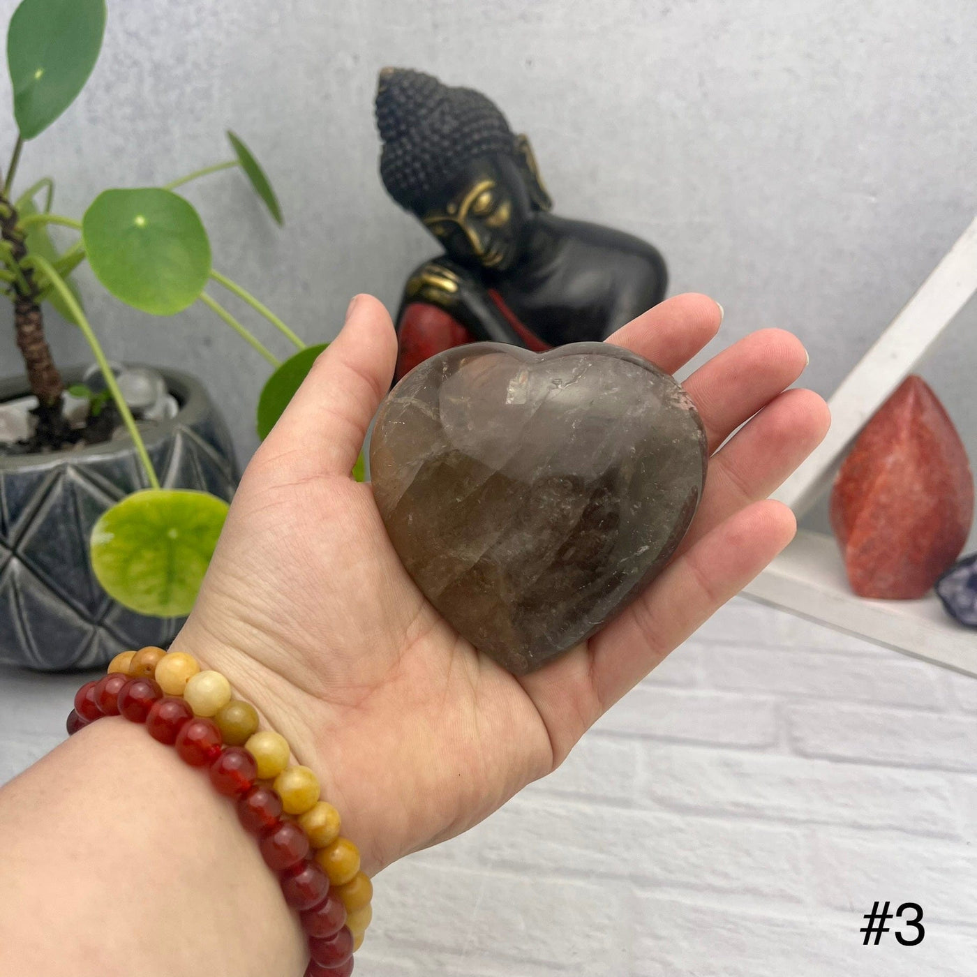 Smokey Quartz Polished Puff Hearts - front view of choice number three in hand for size reference
