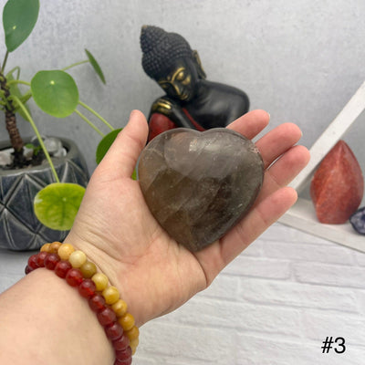 Smokey Quartz Polished Puff Hearts - front view of choice number three in hand for size reference