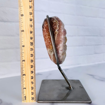 side view of Pink Amethyst Druzy Moon on Metal Stand pictured next to a ruler for sizing reference